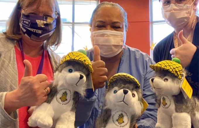 Healthcare workers with Dash the Dog from Pineapple Hospitality