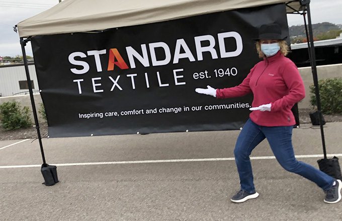 Person standing in front of Standard Textile sign