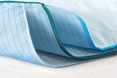 A stack of three DermaTherapy® underpads are shown here. DermaTherapy® bed linens are FDA Cleared therapeutic linens engineered to prevent pressure injuries, improve patient outcomes, and reduce operational costs.
