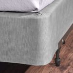 Encircle™ box spring cover in magnesium installed on a hotel bed