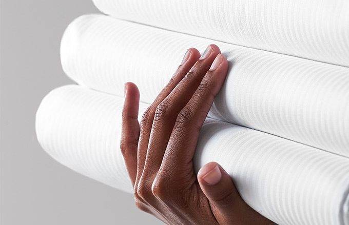 Woman's hand holding a stack of hotel towels