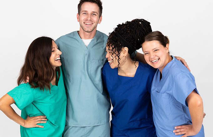 Four model nurses wearing scrubs