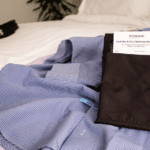 VersaValet laundry garment bag laying on a shirt on a hotel bed