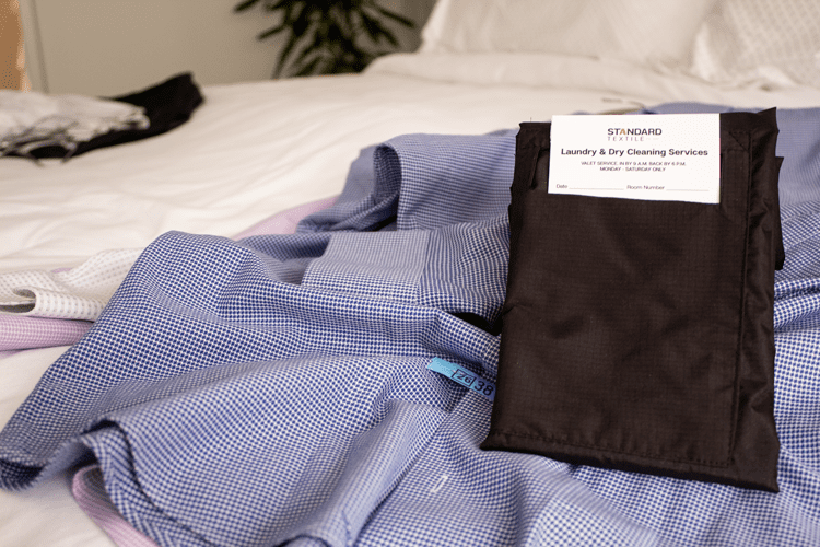 VersaValet laundry garment bag laying on a shirt on a hotel bed
