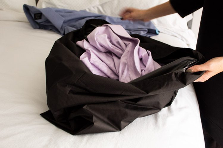 Hotel guest filling VersaValet hybrid garment laundry bag