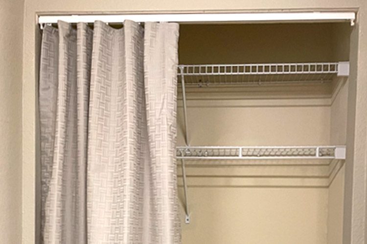 Shown here in this image is a closet with drapery. The fabric pattern and color way is Bezel in Cinderblock.
