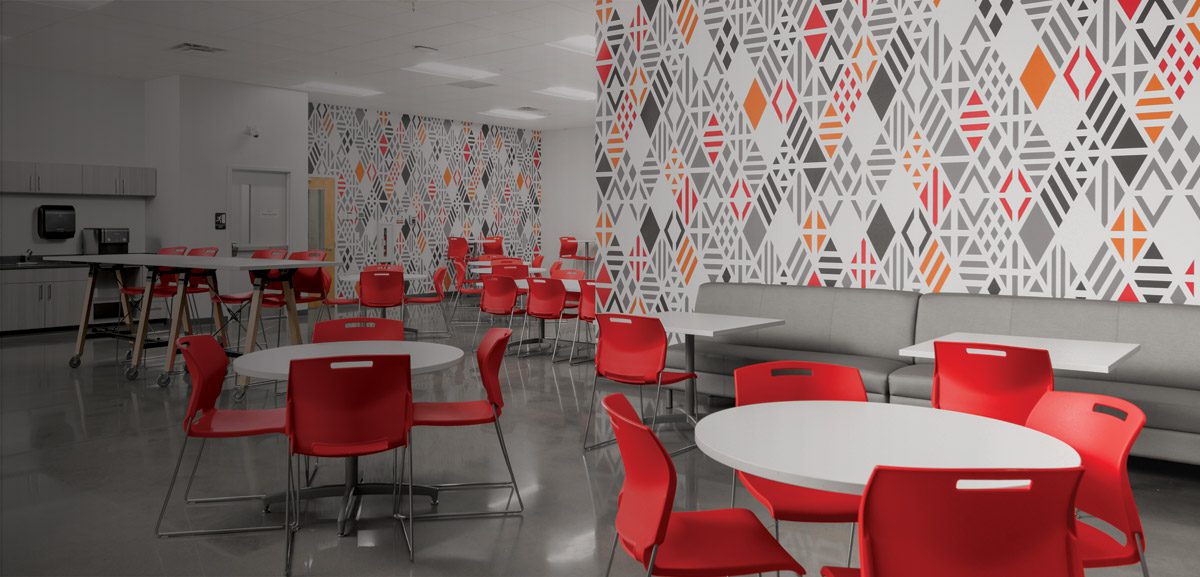 Image of cafeteria with red chairs and striking wallcovering.