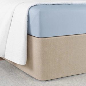 Corner of a bed featuring the Circa Bed Wrap Ready-to-Ship Fabric in the color way called Rice Paper.