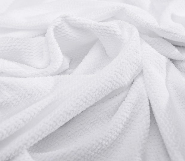 Detail of the texture of the Lynova white cotton blanket.