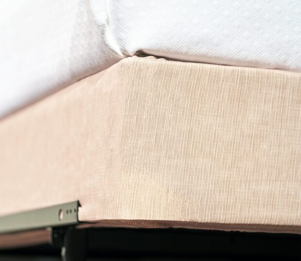 Encircle Box Spring Cover in the color Sand. Detail corner shot of basketweave fabric.