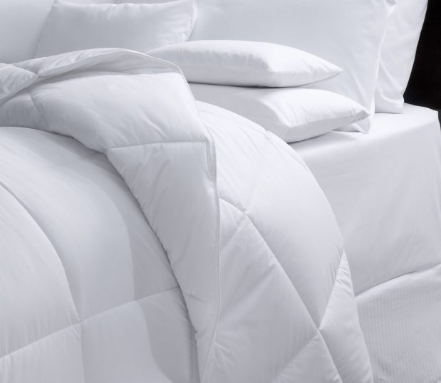 Image of a bed beautifully made with a Luxsoft oversized comforter.