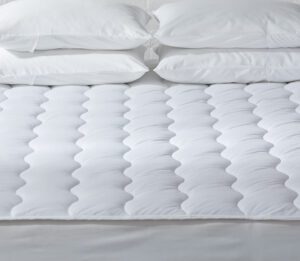 Image is of a Comfort Cloud a plush mattress pad shown on a bed with pillows.