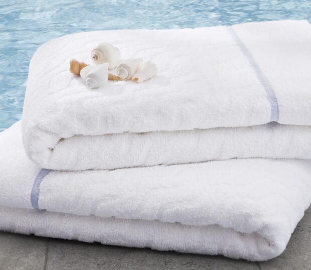 an image of our EuroSpa blue terry beside a hotel pool with shells on top.