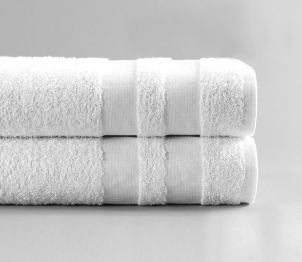 This image of our Value Line Bath Towel is shot folded and stacked on a white background. This hospital towel was originally intended for hotels so it is a great value and incredibly soft.