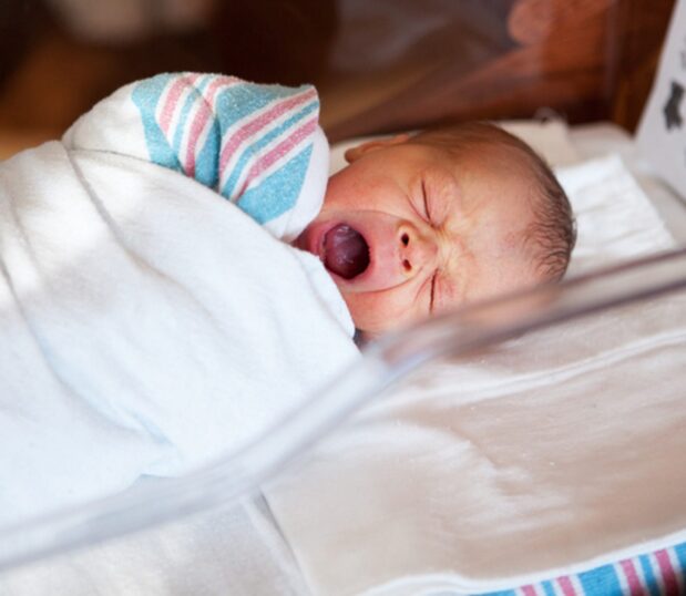 Our Striped Baby Blankets feature a cotton-rich fabric made to provide all the softness and warmth required for life’s first moments. Featuring classic pink & blue stripes. Shown here: an infant wrapped in the striped baby blanket.