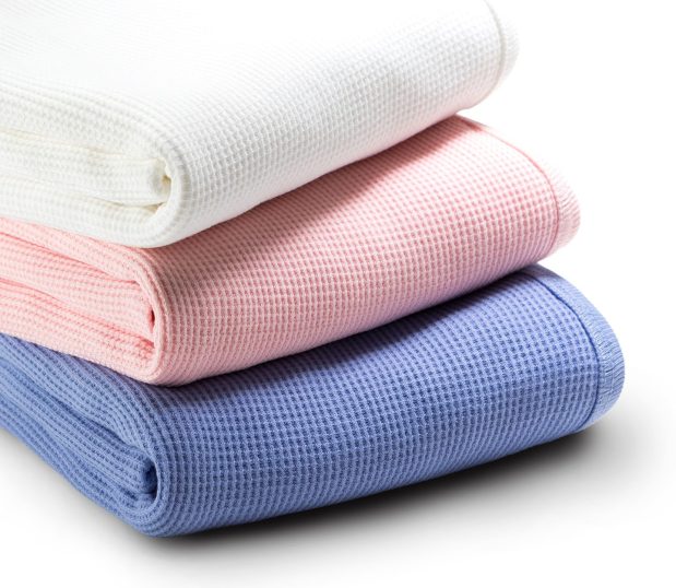 Three of our Waffle Baby Blankets stacked to reveal the waffle texture. These baby blankets feature an all-cotton waffle knit fabric made to provide all the softness and warmth required for life’s first moments.