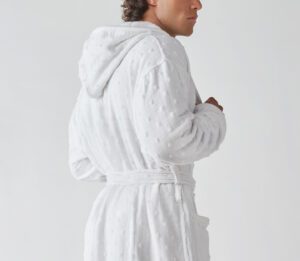 The Billy Bathrobe is a white cotton bathrobe and has a hood, pockets and a woven polka-dot pattern.