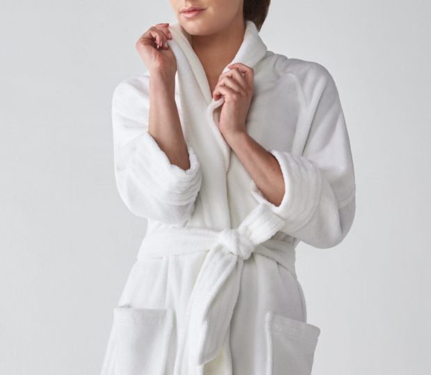 model shown wearing the Nikki Bathrobe. This luxurious white bathrobe features a shawl collar and pockets. Heidi Weisel robes are uniquely, fashionable bathrobes.