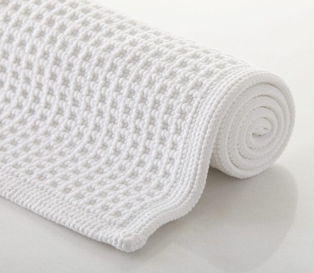 Luxury bath rug Artesano Grid rolled the show depth of texture of the rug.