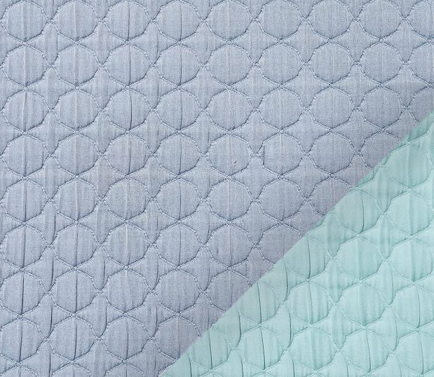 This image shows a detail of the Reversible, Moroccan Matelassé Bedspread, non-quilted matelassé, shown in Chambray.