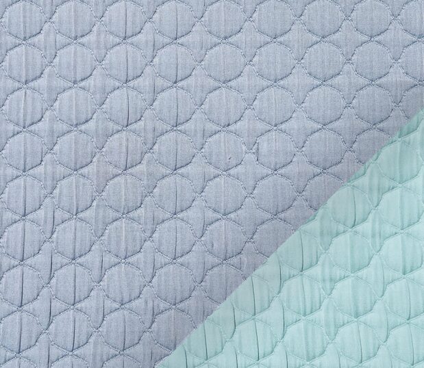 This image shows a detail of the Reversible, Moroccan Matelassé Bedspread, non-quilted matelassé, shown in Chambray.