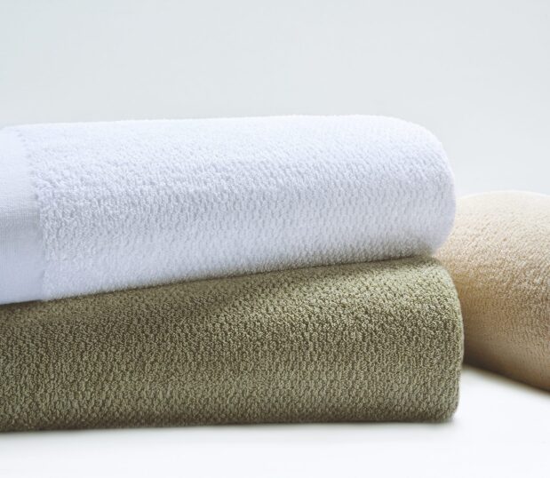 The Dual Cover® Blanket is shown here stacked. Three of the colorways are shown here. These hospital blankets are available in bleached white or 7 different vat dyed color options.