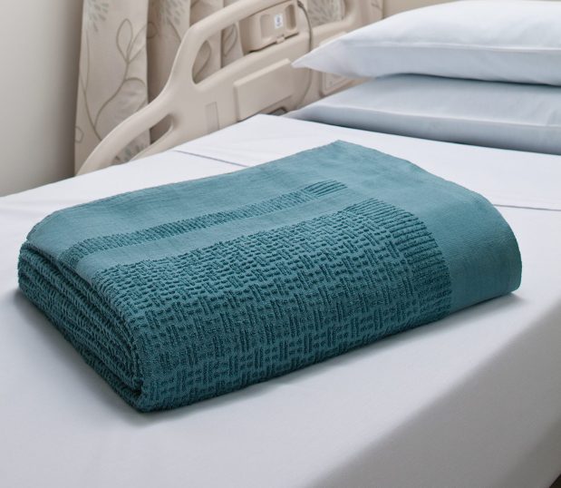 Our Insulite® Blanket delivers patient warmth shown here folded laying on a hospital bed.
