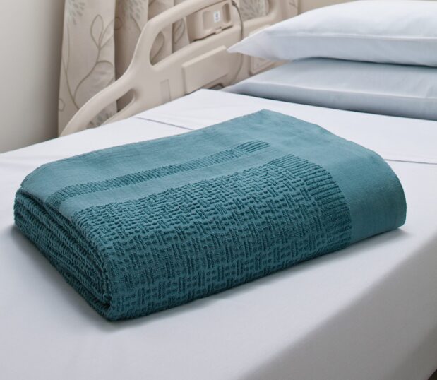 Our Insulite® Blanket delivers patient warmth shown here folded laying on a hospital bed.