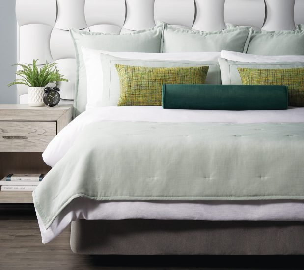 Custom Top of Bed featuring ImagePoint pillows on a white bed with a pale green throw and shams.