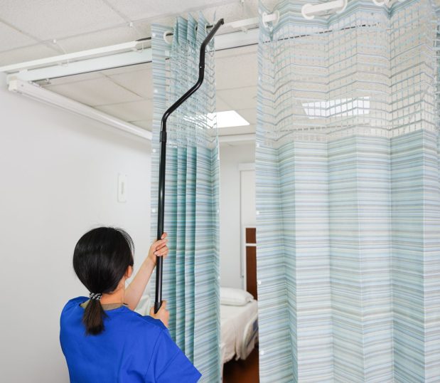 A nurse is seen here replacing the On the Right Track Disposable Privacy Curtains.