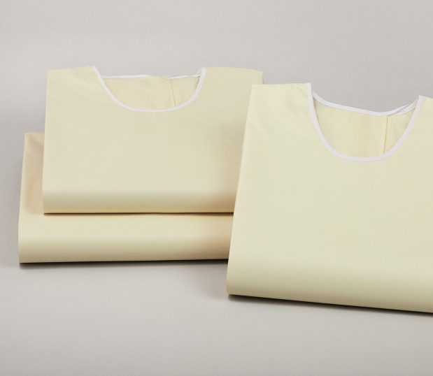Image of a stack of three ComPel® Reusable Isolation Gowns. These gowns are latex free and virtually lint free.