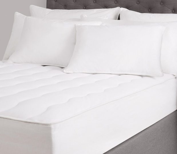 Shown here: a plush Comfort Cloud mattress pad shown on a bed with pillows.