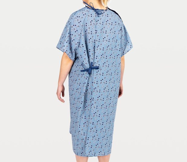 This image shows a female patient in the blue Keystone E*Star® Patient Gown. This back view of the hospital gown shows the dark blue ties at neck and waist.