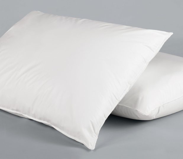 Two white VinSoft® Pillows, one propped up against the other. These pillow are wholesale hospital pillows.