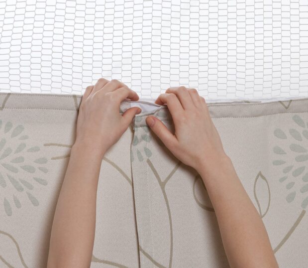 Hands snapping the final snaps on the Perfect Panel Privacy Curtain showing how easy they are to install. Consider privacy curtains when replacing your cubicle curtains.