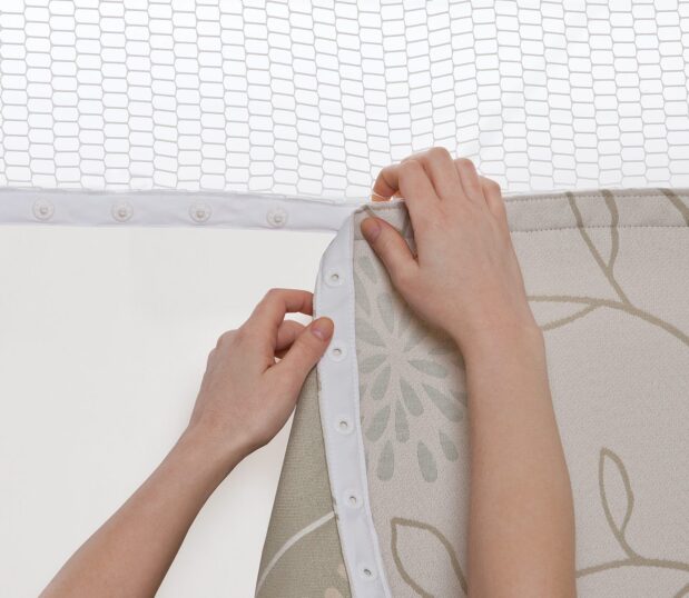 Hands snapping the Perfect Panel Privacy Curtain onto the mesh. These custom privacy curtains are easy to replace.