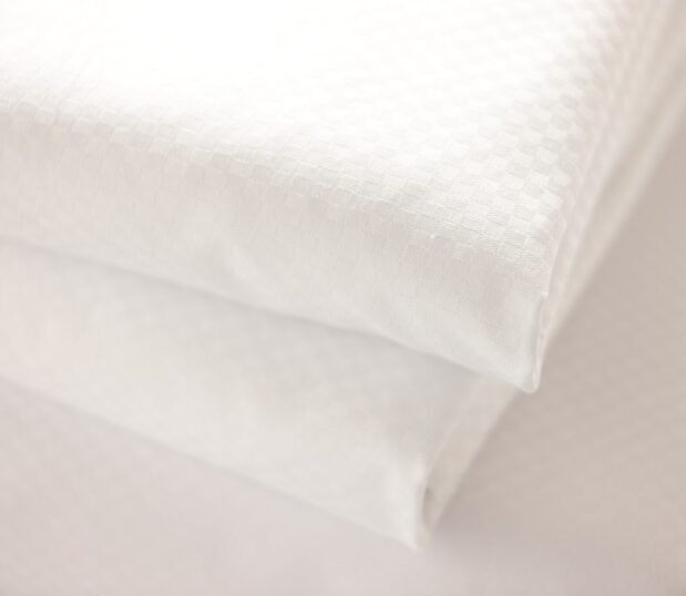 Image shows a detail shot of Centium Satin Microcheck sheets.