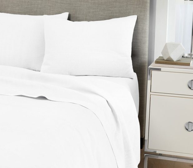 Image shows our luxurious Centium Satin sheets and pillowcases on a hotel bed.