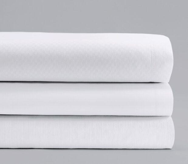 Stack of three ComforTwill sheets in all three patterns: microcheck, tone-on-tone and solid.