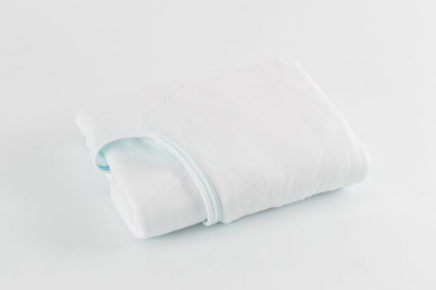 E*Star® Fitted Sheets in White jersey knit sewn with aqua binding. Shown folded.