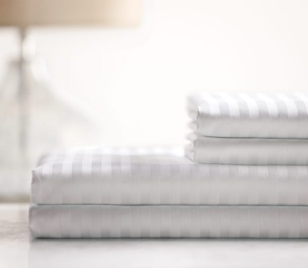 Image of a stack of luxury striped sheets.