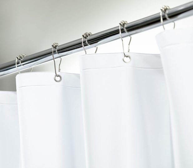 Detail of stainless steel roller ball shower curtain rings on a rod with a shower curtain.