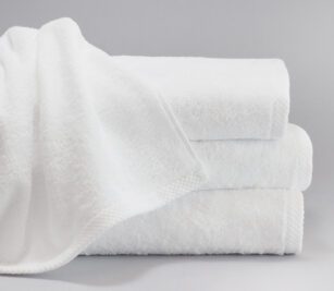 A stack of white towels featuring a dobby hem. ForeverSoft towels are towels that stay soft.