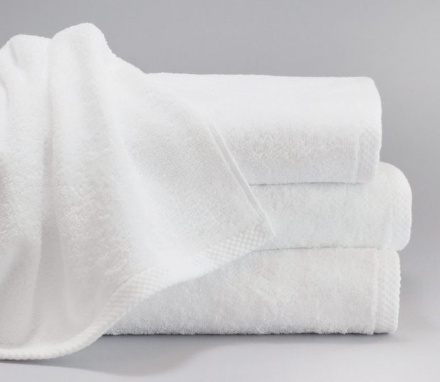 A stack of white towels featuring a dobby hem. ForeverSoft towels are towels that stay soft.