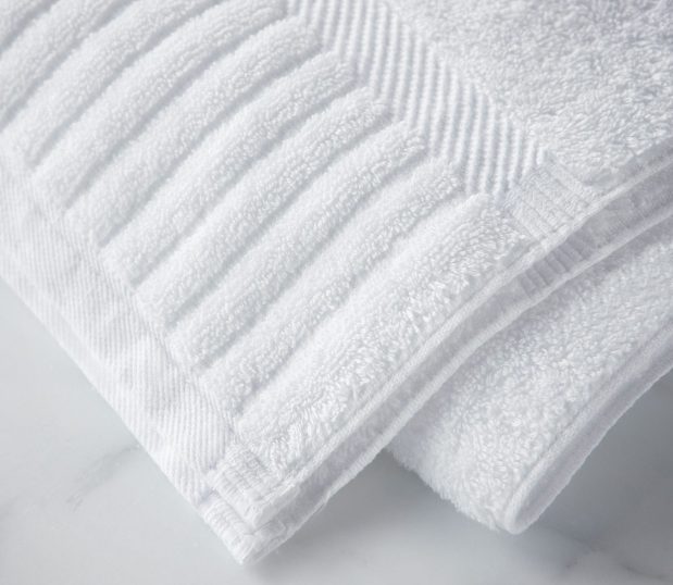 The Piano Key collection features 100% cotton hotel towels with an elegant dobby border. The sophisticated look is finished with distinctive piano key end panels. Image shows a detail shot of the piano key towel.