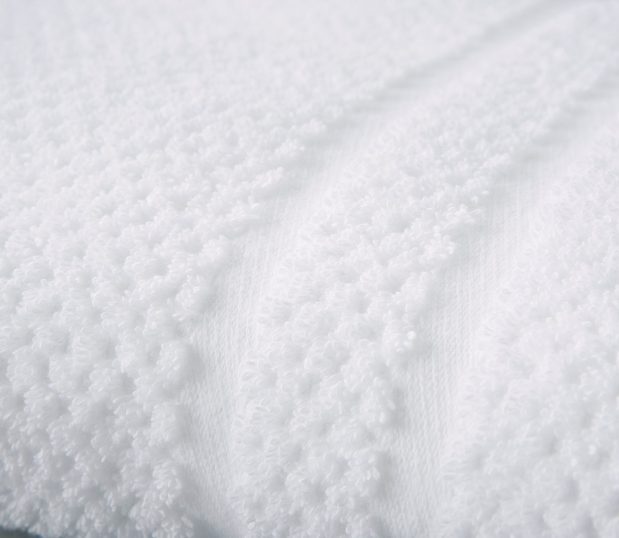 Detail of the of pique weave towels. These are unique jacquard towels with their overall dotted texture and two thin dobby borders.