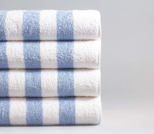 Set of four Cabana Blue striped pool towels. The towels have alternating blue and white stripes.