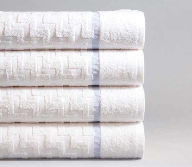 Stack of four colorfilled pool towel. These luxury pool towels have the Stairstep pattern, and a blue cam.