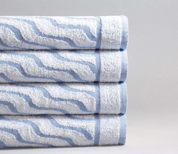 Stack of 4 colorfilled pool towel. These luxury pool towels have the Wave design with blue weft.