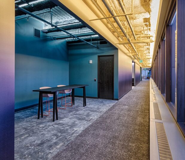 Work space with custom wallcovering in the hallway with a gradient from Yellow to Purple.